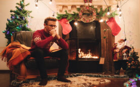 Man,In,Red,Sweater,Sitting,In,Front,Of,The,Fireplace.