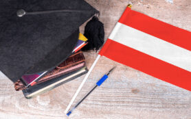 Black,Graduation,Hat,On,Books,Next,To,Austria,Flag,,Education