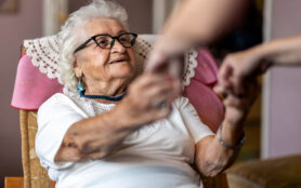 Female,Home,Carer,Supporting,Old,Woman,To,Stand,Up,From