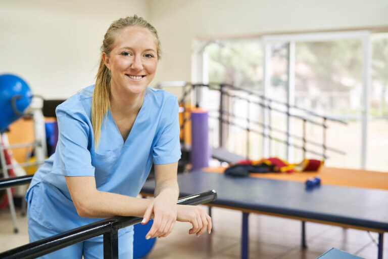 Smiling,Young,Woman,As,Physiotherapist,Standing,In,Gym,Of,Nursing