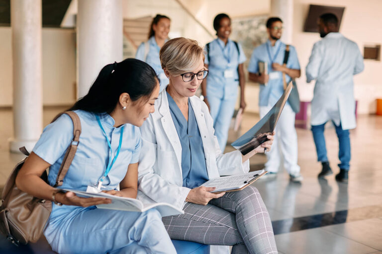Medical,Professor,And,Her,Asian,Student,Reading,Data,While,Examining