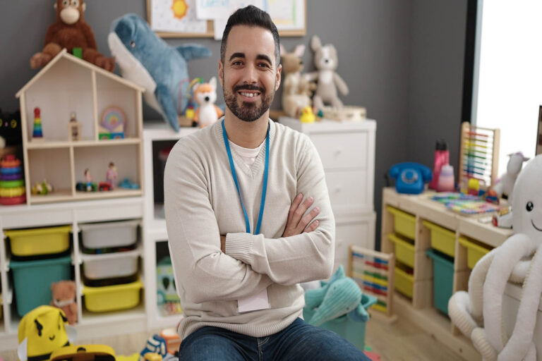 Young,Hispanic,Man,Teacher,Smiling,Confident,Sitting,With,Arms,Crossed