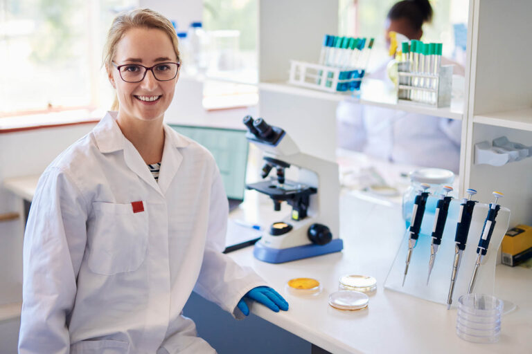Portrait,Of,A,Young,Female,Lab,Technician,Smiling,While,Sitting