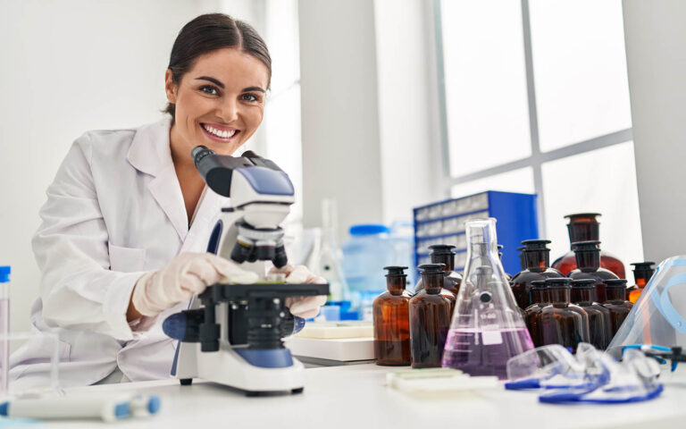 Young,Beautiful,Hispanic,Woman,Scientist,Smiling,Confident,Using,Microscope,At