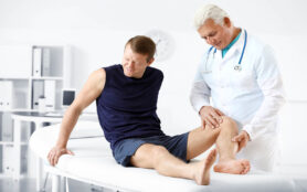 Mature,Doctor,Examining,Sportsman,With,Joint,Pain,In,Clinic